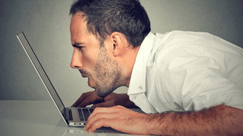 Man struggling to read his laptop