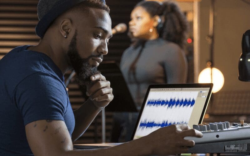 man editing music on laptop
