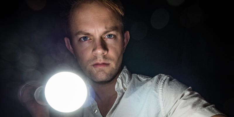 man with torch looking into camera