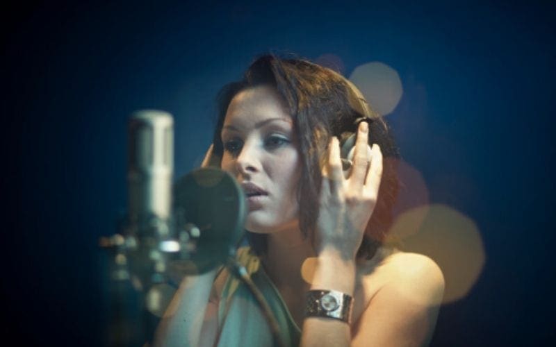 Woman sings into a microphone