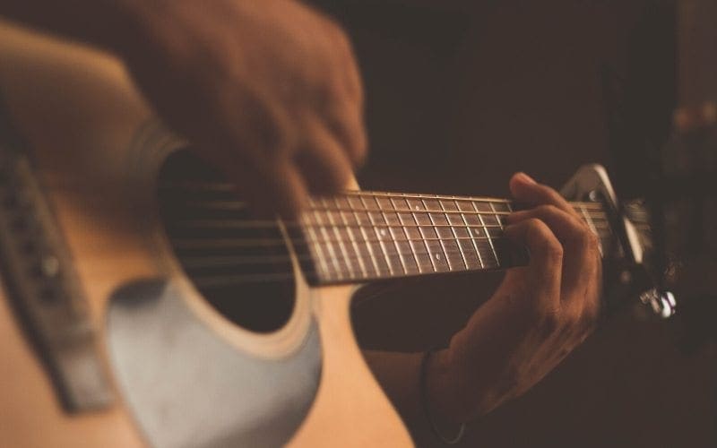 person playing acoustic guitar