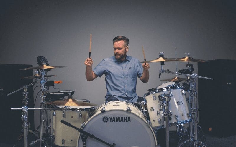 man shows how to set up a drum set