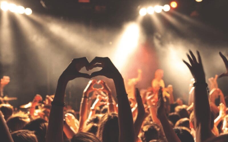 People at ADE doing hand signs in the crowd.