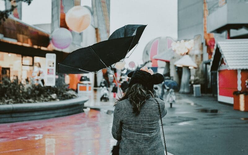 woman with broken umbrella on a windy day