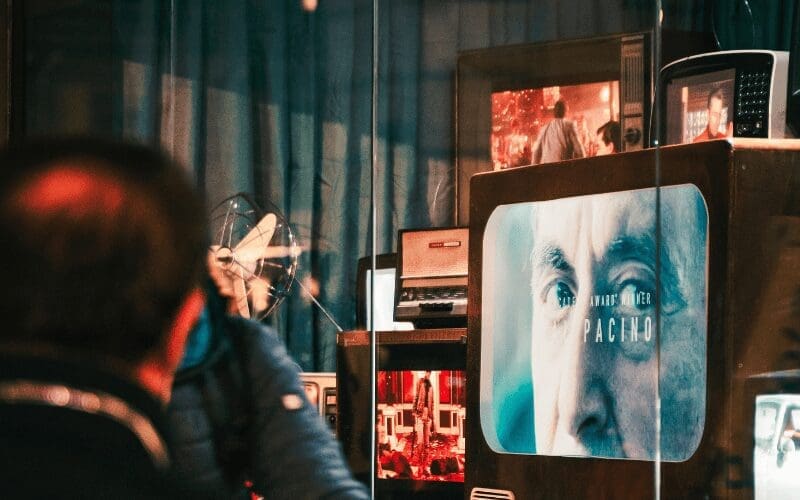 man looking at TV's in shop window