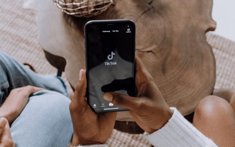 a person holding a phone opening TikTok